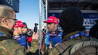 Zwei Sportler werden von zwei Soldaten in Uniform interviewt.