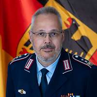 Ein Soldat vor einer Deutschlandflagge