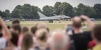 Viele Besucher beobachten ein Kampfflugzeug Eurofighter auf der Startbahn.