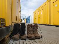 Service members’ boots standing between accommodation containers