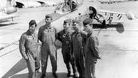Eine Gruppe Piloten steht an einem Düsenjet.