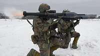 Zwei Rekruten im Schnee schießen mit der Panzerfaust 3. Flammen schlagen hinten aus der Waffe.