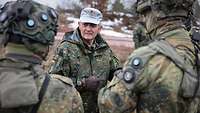 General Sollfrank im Gespräch mit Soldaten auf einem Feld im Winter.