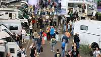 Besucher und Wohnmobile in einer Messehalle