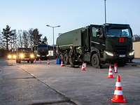 Ein militärischer Tanklastwagen wartet mit einem Soldaten auf einfahrende Militärfahrzeuge