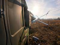 Eine Kamikazedrohne fliegt auf einen LKW zu. Sie ist kurz vor dem Einschlag.