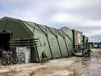 Ein Rettungszelt an einem Lastwagen befestigt mit einem Sanitätskreuz