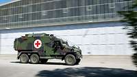 Ein militärisches Sanitätsfahrzeug mit sechs Rädern in Vorbeifahrt