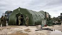 Ein Zelt, drum herum Soldaten. Im Hintergrund ein LKW aus dem das Zelt aufgebaut wurde.
