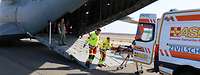 Ziviler Rettungsdienst beim ausladen eines Patienten aus dem Flugzeug, direkt in einen Rettungswagen