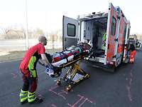 Ein Sanitäter schiebt eine Transportliege in einen Rettungswagen