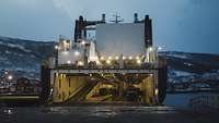 Fähre mit geöffneter Heckrampe bei Dämmerung im Hafen