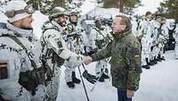 Boris Pistorius schüttelt einem Soldaten in Wintertarn die Hand.