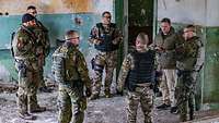 Mehrere Soldaten stehen in einer Gruppe zusammen und besprechen die Lage