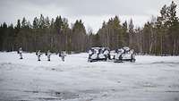 German mountain infantry troops in snow camouflage march over snow-covered terrain.