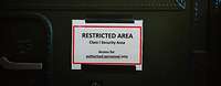 Ein Schild mit dem Schriftzug "Restricted Area" auf einer Containertür zum DCRC