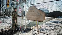 Ein Soldat schließt die Eingangstür. Am Zaun hängt ein Holzschild mit der Aufschrift „DCRC“.