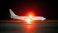 Ein Flugzeug P8A Poseidon auf der Landebahn bei Nacht.