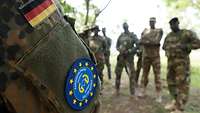 Momentaufnahme: Arm mit Patch des EU-Programms in Hintergrund Soldaten.
