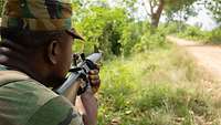 Ein Soldat sichert entlang einer Straße.