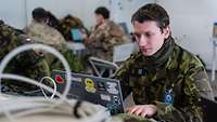 Ein tschechischer Soldat sitzt vor einem Rechner und arbeitet.