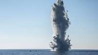 Eine Wasserfontäne schießt auf dem offenem Meer in die Höhe.