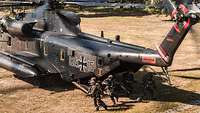 Soldiers of the Bundeswehr special operations forces off-board a helicopter ready to fight.