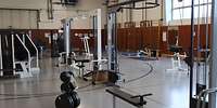 Eine Sporthalle mit verschiedenen Fitnessgeräten aus Metall