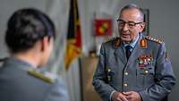 Eine Soldatin spricht mit Generalinspekteur Carsten Breuer in einem Büro.