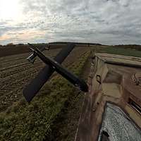 Eine Kamikazedrohne fliegt auf ein Fahrzeug zu. Sie ist kurz vor dem Einschlag.