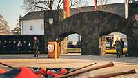 Appellplatz mit einen Soldat hinter einem Rednerpult, sitzenden Gästen und der Pionierbrücke