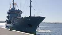 Ein Schiff der Marine nähert sich der Kaimauer.