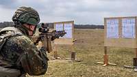 Ein Soldat beim Schießen mit dem Gewehr G95. Vor ihm stehen Ständer darauf Zielscheiben.