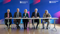 Mehrere Personen sitzen an einem Tisch.