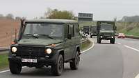 Mehrere Fahrzeuge der Bundeswehr fahren von einer Autobahn ab