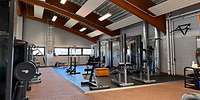 Blick in einem Hallenbereich mit verschiedenen Fitnessgeräten aus Metall
