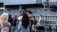 Ein Soldat verabschiedet sich von einem Kind vor dem Schiff "Fulda"