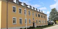 Zweigeschossiges, gelb gestrichenes Gebäude mit Gauben