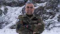 Soldat steht vor einem verschneitem Berg.