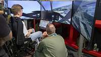 Ein Besucher der ILA 2024 sitzt in einem Flugsimulator der Bundeswehr.