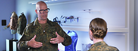 Eine Soldatin und ein Soldat stehen sich gegenüber und sprechen miteinander.