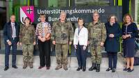 Soldaten und Zivilisten stehen in einer Reihe