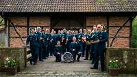 Gruppenfoto der Egerländerbesetzung vor Mühle