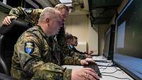 Soldaten sitzen bei der Marineübung Mjølner vor Bildschirmen