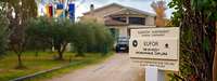 Vor einem Gebäude steht ein Schild mit der Aufschrift EUFOR