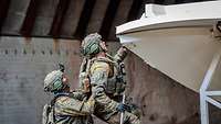Zwei Soldaten beim Aufbau der großen weißen Satelliten-Schüssel.