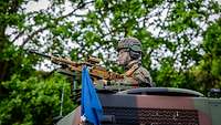 Ein Soldat bemannt ein auf einem LKW montiertes Maschinengewehr durch die Dachluke.