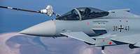 Ein Kampfflugzeug fliegt in der Luft und ist mit einem Tankschlauch verbunden.