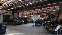 Mehrere historische Panzer stehen in einem Museum.