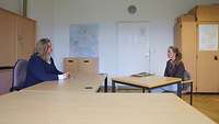 Zwei Frauen an einem Tisch im Gespräch